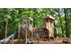 Wooden playground structure with slide, climbing areas, and shaded by tall trees in a forest setting at 3912 Edenton Ne Ct, Brookhaven, GA 30319