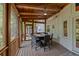 Covered screened porch with wood ceiling featuring table with chairs, heater, and view of wooded backyard at 3912 Edenton Ne Ct, Brookhaven, GA 30319