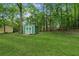 Green storage shed in a spacious, lush backyard adding both function and charm at 3935 Hamilton View Way, Dacula, GA 30019