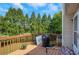 Wooden deck overlooking the backyard with green trees and a wooden fence in the background at 1740 Ambercrest Pl, Buford, GA 30518