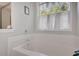 Bright bathroom featuring a soaking tub with white tiled surround and a window at 1740 Ambercrest Pl, Buford, GA 30518