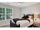 Bedroom with a dark wood bed frame, plush pillows and large window at 1740 Ambercrest Pl, Buford, GA 30518