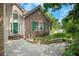 Charming brick home with a green door and shutters and a landscaped yard with stone path at 1740 Ambercrest Pl, Buford, GA 30518