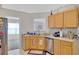 Charming kitchen featuring wood cabinets, stainless steel dishwasher, and open view to the next room at 1740 Ambercrest Pl, Buford, GA 30518