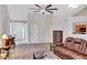 Cozy living room with a large ceiling fan, piano, and a comfortable-looking leather sofa at 1740 Ambercrest Pl, Buford, GA 30518