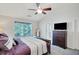 Bedroom with a dark wood bed frame, plush pillows and ceiling fan at 1740 Ambercrest Pl, Buford, GA 30518