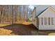 View of the backyard featuring trees and the back of the house with shuttered windows at 205 Carrington Pt, Canton, GA 30115