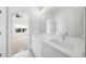 Bright bathroom featuring a large mirror over double vanity and view to bedroom at 205 Carrington Pt, Canton, GA 30115