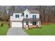Charming two-story home featuring white siding, brick accents, covered porch, and an attached two-car garage at 205 Carrington Pt, Canton, GA 30115
