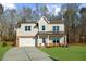 Charming two-story home with a brick-accented facade, two-car garage, and a well-manicured front lawn at 205 Carrington Pt, Canton, GA 30115
