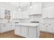 Charming kitchen boasts white cabinets, a center island, and a view of the outdoors at 205 Carrington Pt, Canton, GA 30115
