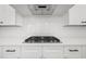 Kitchen close-up featuring a modern range with white cabinets and subway tile backsplash at 205 Carrington Pt, Canton, GA 30115