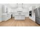 Bright kitchen features white cabinets, stainless steel appliances, hardwood floors, and a center island at 205 Carrington Pt, Canton, GA 30115