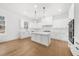 Modern, open-concept kitchen featuring white cabinets, a large island, and stainless steel appliances at 205 Carrington Pt, Canton, GA 30115