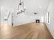Bright living room with fireplace, ceiling fan, and modern light fixture near the staircase at 205 Carrington Pt, Canton, GA 30115