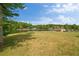 Vast green lawn leading to a serene lake, complemented by lush, mature trees at 2191 Lakeview Pkwy, Villa Rica, GA 30180