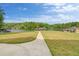 Expansive backyard with a paved path leading towards the tranquil lake at 2191 Lakeview Pkwy, Villa Rica, GA 30180