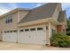 Two car garage of a home with tan siding and a brick facade at 2191 Lakeview Pkwy, Villa Rica, GA 30180