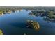 Breathtaking aerial view of a serene lake featuring a tree-covered island with a private dock and surrounding residences at 2191 Lakeview Pkwy, Villa Rica, GA 30180