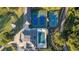 Aerial view of tennis courts and a pool with cabana, surrounded by lush landscaping and manicured grounds at 2191 Lakeview Pkwy, Villa Rica, GA 30180
