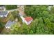 Aerial back view of a light grey two-story home with a red roof in the woods at 31 Fairview Oak Cv, Dallas, GA 30157