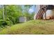 Grassy backyard featuring a small shed with a window and double doors at 31 Fairview Oak Cv, Dallas, GA 30157