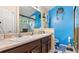 Bright bathroom with dual sinks, blue accent wall, and glass-enclosed shower at 31 Fairview Oak Cv, Dallas, GA 30157