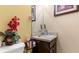 Cozy half bathroom with a corner vanity, mirror, and red flowers as decor at 31 Fairview Oak Cv, Dallas, GA 30157
