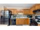 Well-appointed kitchen with black appliances, granite countertops, and wooden cabinets at 31 Fairview Oak Cv, Dallas, GA 30157