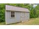 Exterior side view of a backyard shed with light grey siding and double doors at 31 Fairview Oak Cv, Dallas, GA 30157