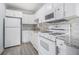 Well-lit kitchen with white appliances, granite countertops, and tiled backsplash at 620 Peachtree Ne St # 601, Atlanta, GA 30308