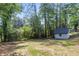 Backyard featuring a well maintained lawn, garden, trees, shed, and professional landscaping at 6835 Sunny Brook Ln, Atlanta, GA 30328