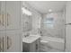 Updated bathroom with marble tile, a modern vanity, and a bathtub with shower combination at 6835 Sunny Brook Ln, Atlanta, GA 30328