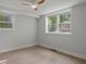 Well-lit bedroom with light-colored walls, wood-look flooring, and two windows for an airy feel at 6835 Sunny Brook Ln, Atlanta, GA 30328