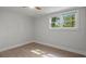 Bright bedroom featuring wood-look floors, ceiling fan, and a window that brings in plenty of natural light at 6835 Sunny Brook Ln, Atlanta, GA 30328