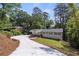 Beautifully renovated home with a long driveway, lush landscaping, and a charming front porch and carport at 6835 Sunny Brook Ln, Atlanta, GA 30328