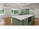 Modern kitchen island with white countertop, green cabinets, and stainless steel appliances, filled with natural light at 6835 Sunny Brook Ln, Atlanta, GA 30328