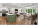 Open-concept kitchen and living area with a fireplace, dining table, and a green kitchen island at 6835 Sunny Brook Ln, Atlanta, GA 30328