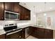 Modern kitchen featuring stainless steel appliances, dark cabinets, and granite countertops at 11130 Benton Woods Dr, Covington, GA 30014