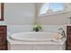 The bathroom features a large soaking tub with marble surround, plus decorative window at 3920 Ineal Dr, Cumming, GA 30028