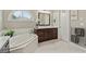 A bathroom featuring a soaking tub, marble floors, and dark wood cabinets at 3920 Ineal Dr, Cumming, GA 30028