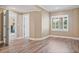 Spacious bedroom with light-colored walls, wood floors, large window, and white trim at 3920 Ineal Dr, Cumming, GA 30028