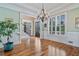 Bright entryway features hardwood floors, a decorative chandelier, and a staircase with wooden banister at 3920 Ineal Dr, Cumming, GA 30028
