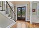 Elegant foyer featuring hardwood floors, a staircase with decorative iron railings, and a grand double door entry at 3920 Ineal Dr, Cumming, GA 30028