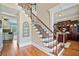 Welcoming foyer with hardwood floors, a staircase with iron railings, and views into the living spaces at 3920 Ineal Dr, Cumming, GA 30028