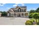 An impressive home with a covered porch, brick and stone accents, and a circular driveway at 3920 Ineal Dr, Cumming, GA 30028