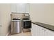 Laundry room with stainless steel appliances, upper cabinets, and tiled floors at 3920 Ineal Dr, Cumming, GA 30028