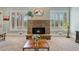 Cozy living room showcasing a stone fireplace flanked by windows and comfortable seating at 3920 Ineal Dr, Cumming, GA 30028