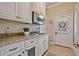 Mudroom features custom cabinets, granite countertops, stainless steel microwave, and direct outdoor access at 3920 Ineal Dr, Cumming, GA 30028