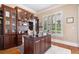 Home office with custom built-ins, hardwood floors, natural light, and a spacious desk at 3920 Ineal Dr, Cumming, GA 30028